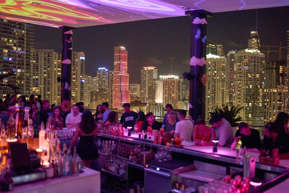 The pink-lit bar of Rosa Sky at night, 22 floors up in Brickell, with the lit-up skyline behind