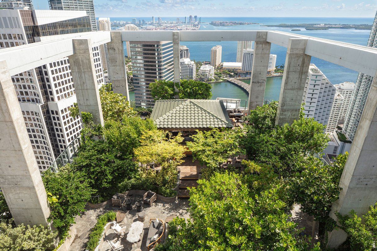 Looking down on the planted rooftop terrace of Sugar on the 40th floor of EAST Miami, with Brickell towers and Biscayne Bay beyond