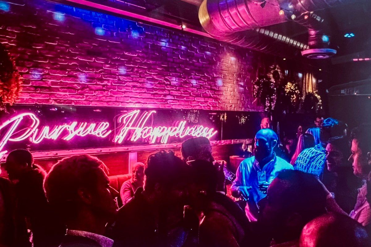 A busy night under the pink neon 'Pursue Happiness' sign at Sweet Liberty, Miami Beach