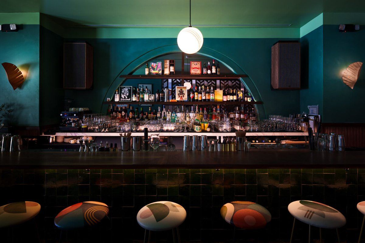 The teal-walled back bar and globe lamp at ViceVersa in The Elser Hotel, Downtown Miami