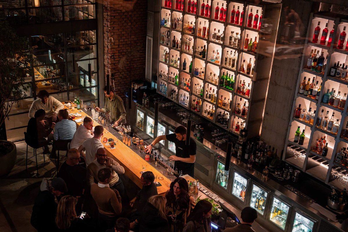 The long bar and back-lit bottle wall at Moebius, Milan