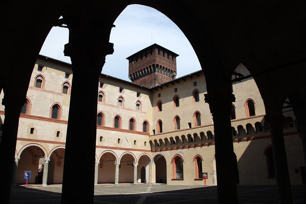 The Rocchetta courtyard of the Castello Sforzesco framed by a dark arch