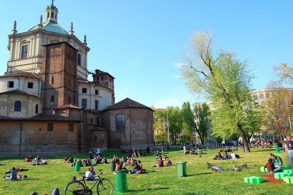 People relaxing on the lawns of the Parco delle Basiliche beneath the basilica of San Lorenzo