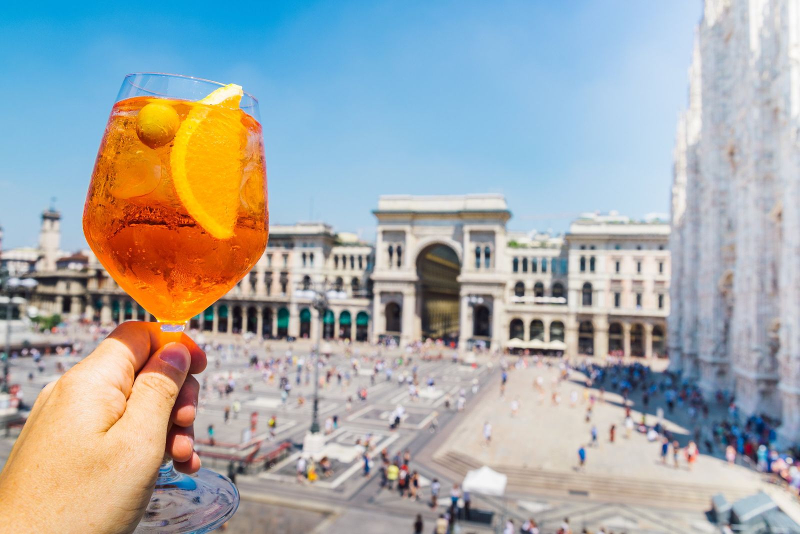 An Aperol spritz with the Piazza del Duomo beyond