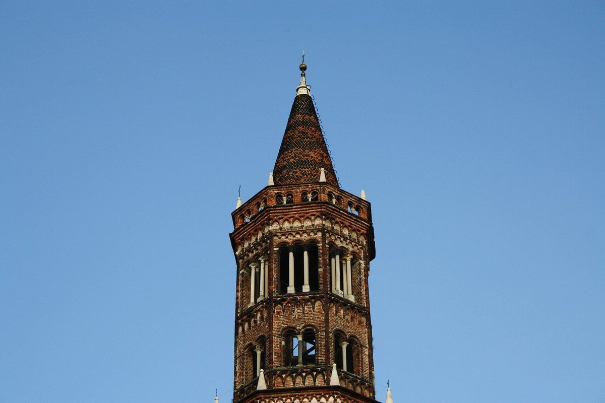 The brick bell tower of Chiaravalle Abbey, the 'Ciribiciaccola', against a blue sky
