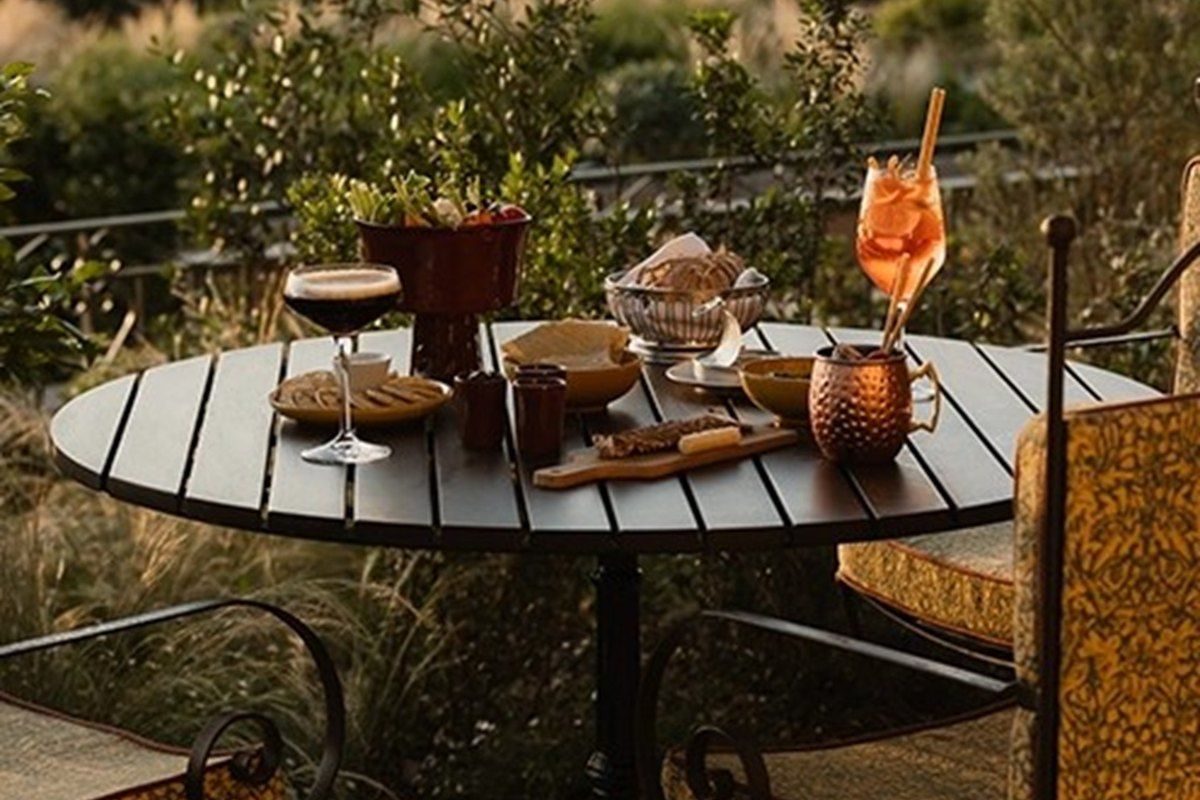 A spritz and nibbles on a terrace table at Le Mas Candille, looking out over the hills at dusk