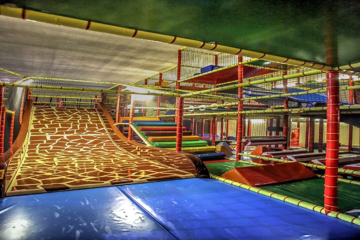 Slides, climbing nets and play structures inside the covered Circus Party park in Mougins