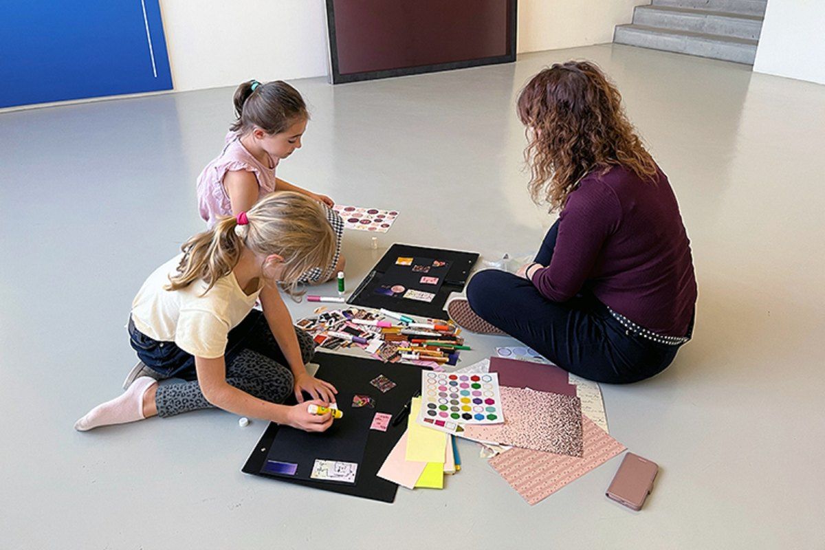 A mother and child making a collage on the floor during a family workshop at the Espace de l'Art Concret