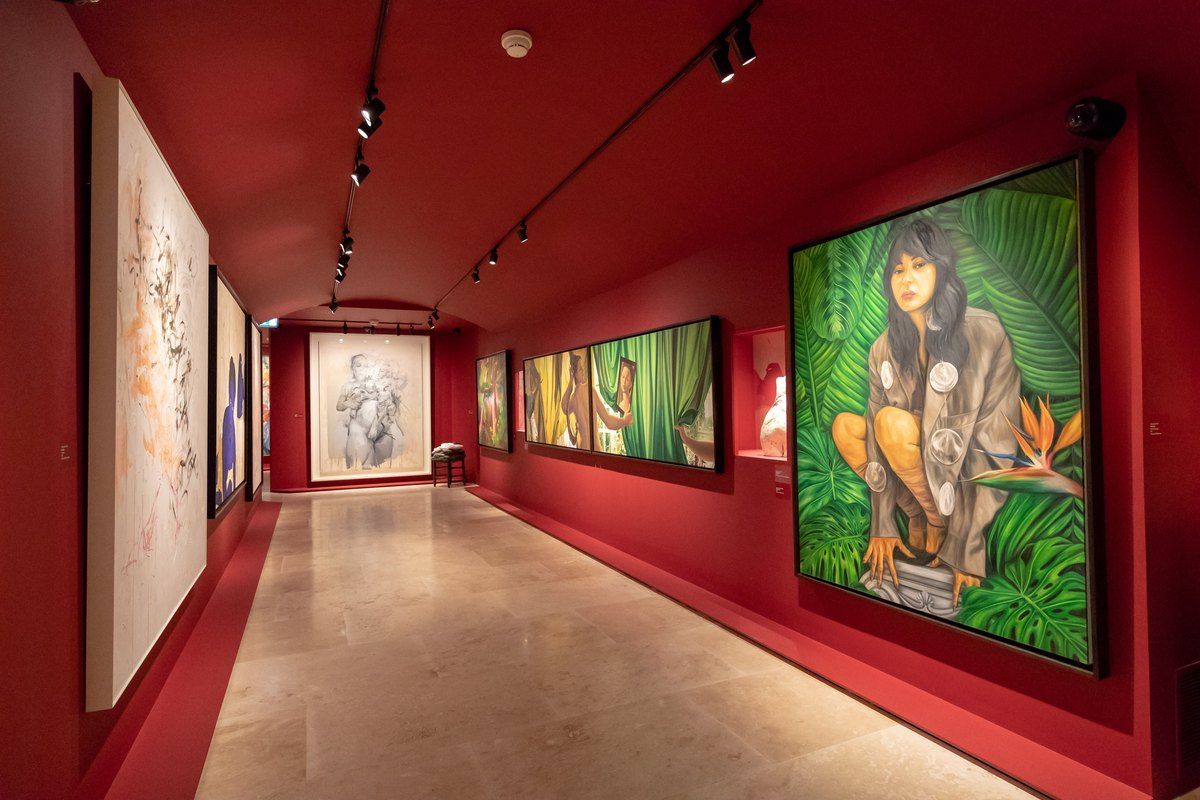 Large paintings on red walls in a gallery of FAMM – Femmes Artistes Musée Mougins