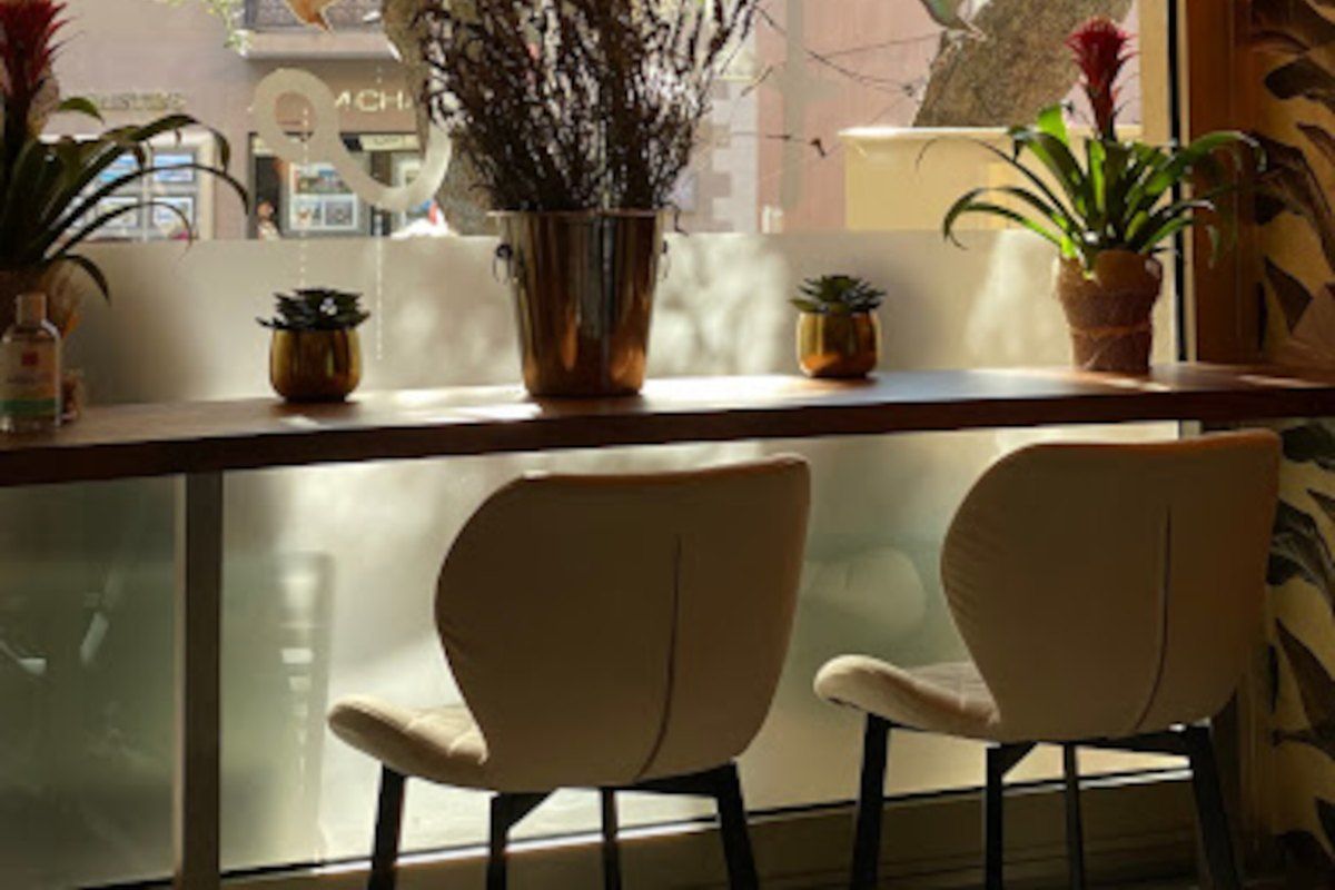 A window counter with stools under a woven lampshade at Pablo in Mougins old village
