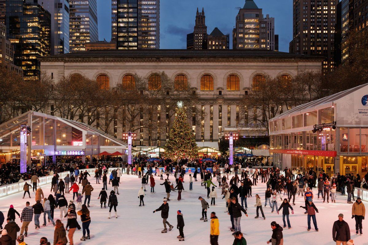 Skaters on the rink at Bank of America Winter Village in Bryant Park, with the Christmas tree and Midtown towers behind