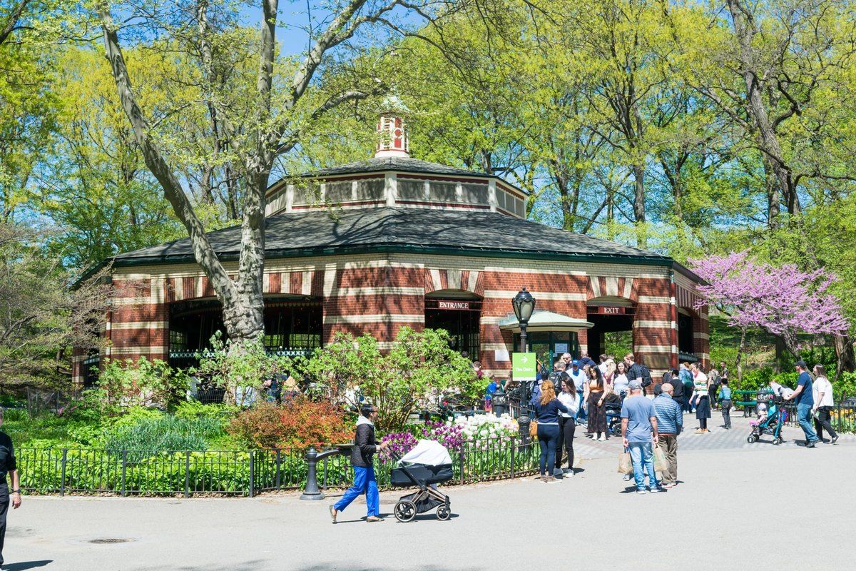 The brick pavilion of the Central Park Carousel among spring trees