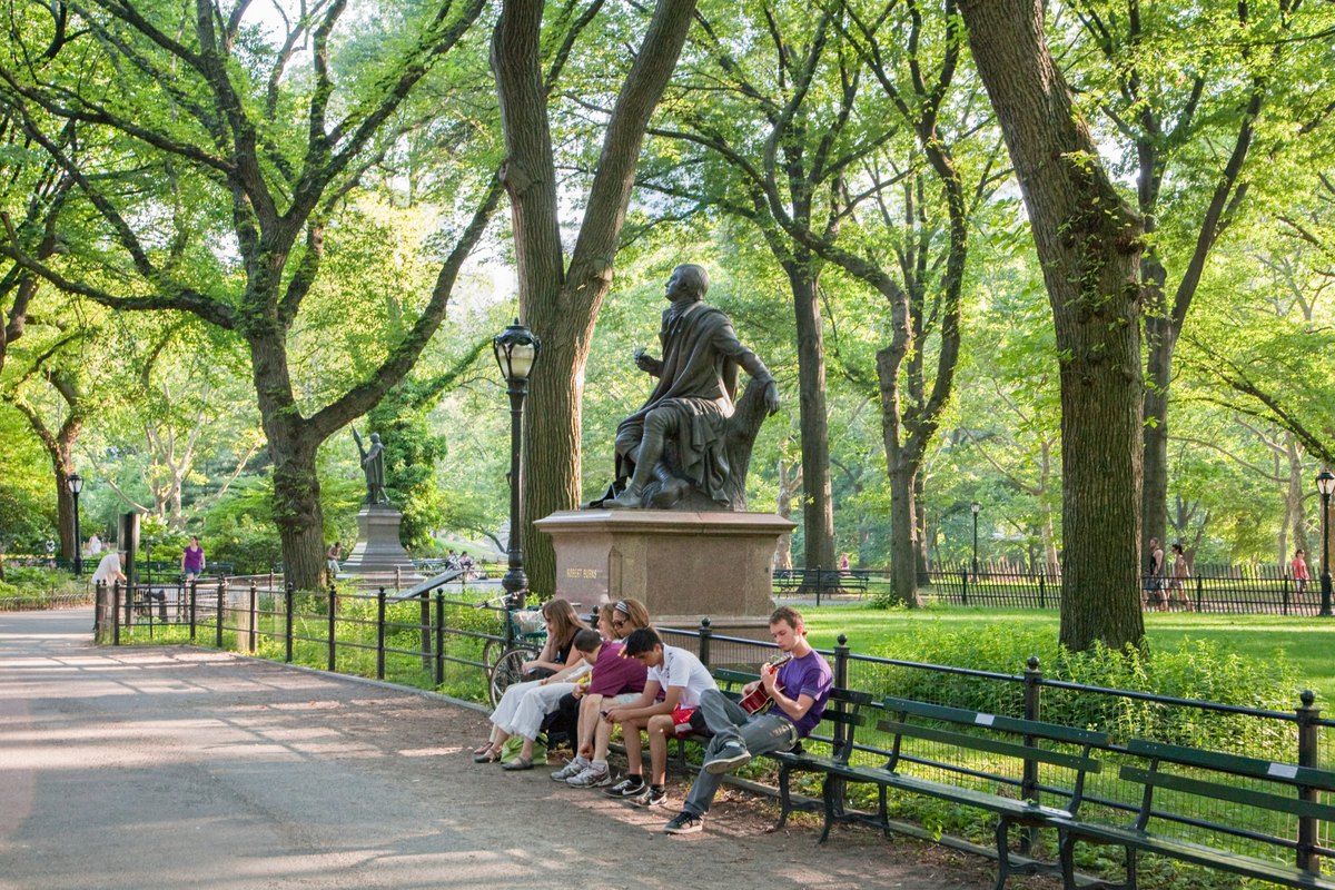 Benches and a writer's statue under the elms of the Literary Walk on the Mall in Central Park