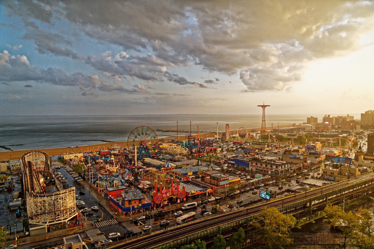 Luna Park and the Coney Island rides seen from above at golden hour, with the ocean beyond