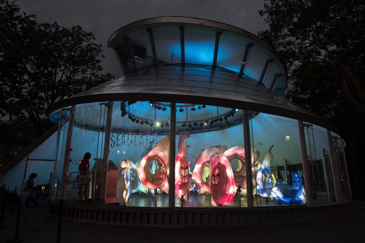 The SeaGlass Carousel glowing blue at dusk in The Battery