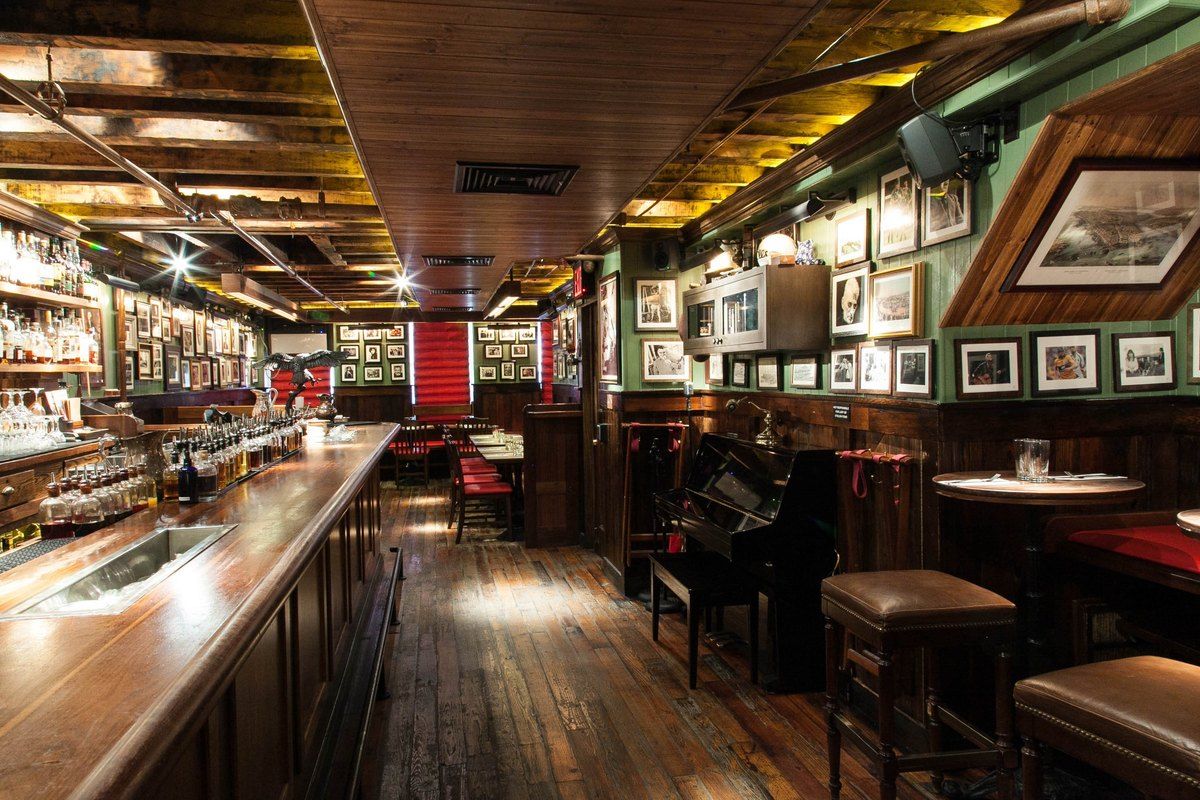The long wooden bar and framed pictures of The Dead Rabbit on Water Street