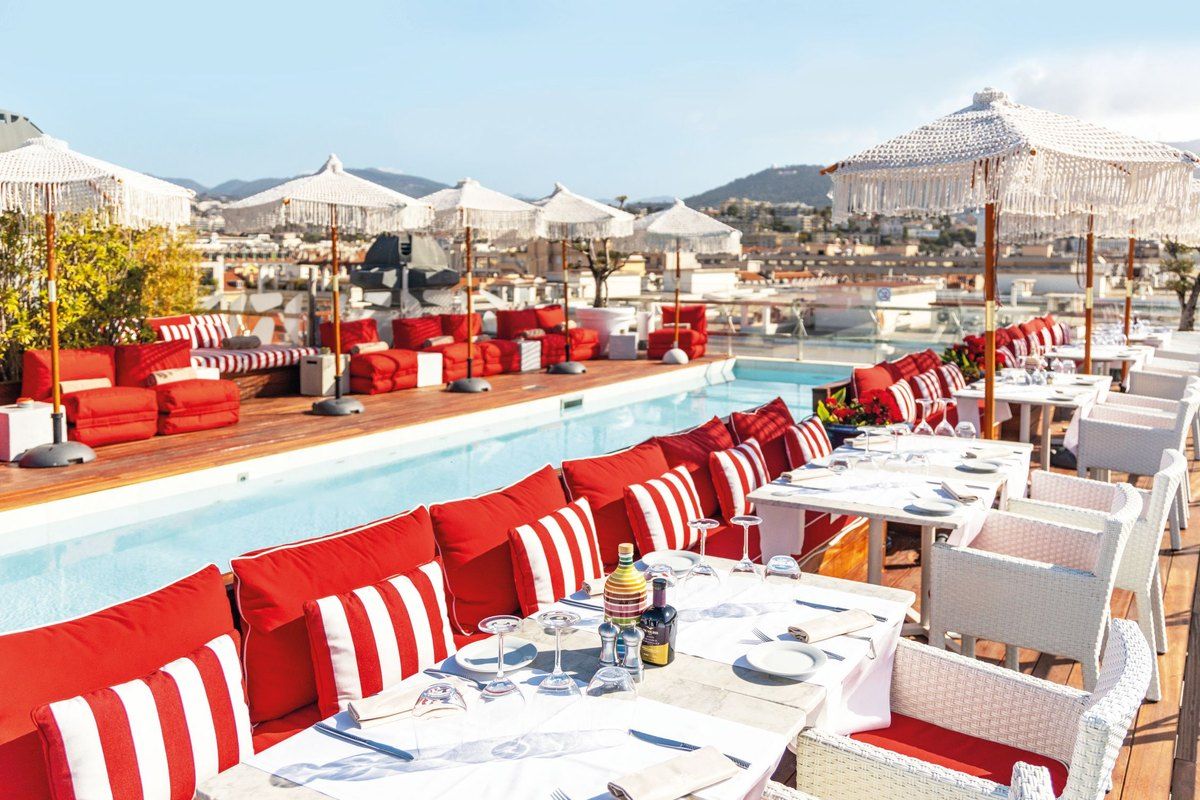 Red-and-white loungers beside the rooftop pool of the Bclub Rooftop at the Boscolo Nice