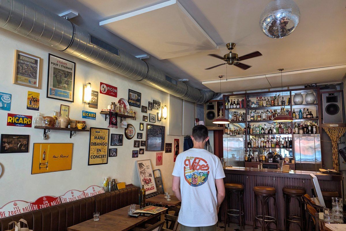 The retro bar of Vibes in a former 1960s garage near the port of Nice, with posters and a disco ball