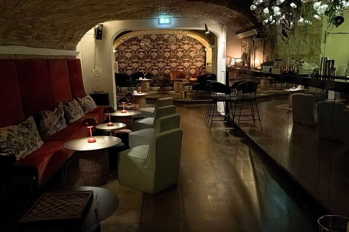 Velvet banquettes and low lights under the vaulted ceiling of Zitto, a hidden cocktail bar in Nice