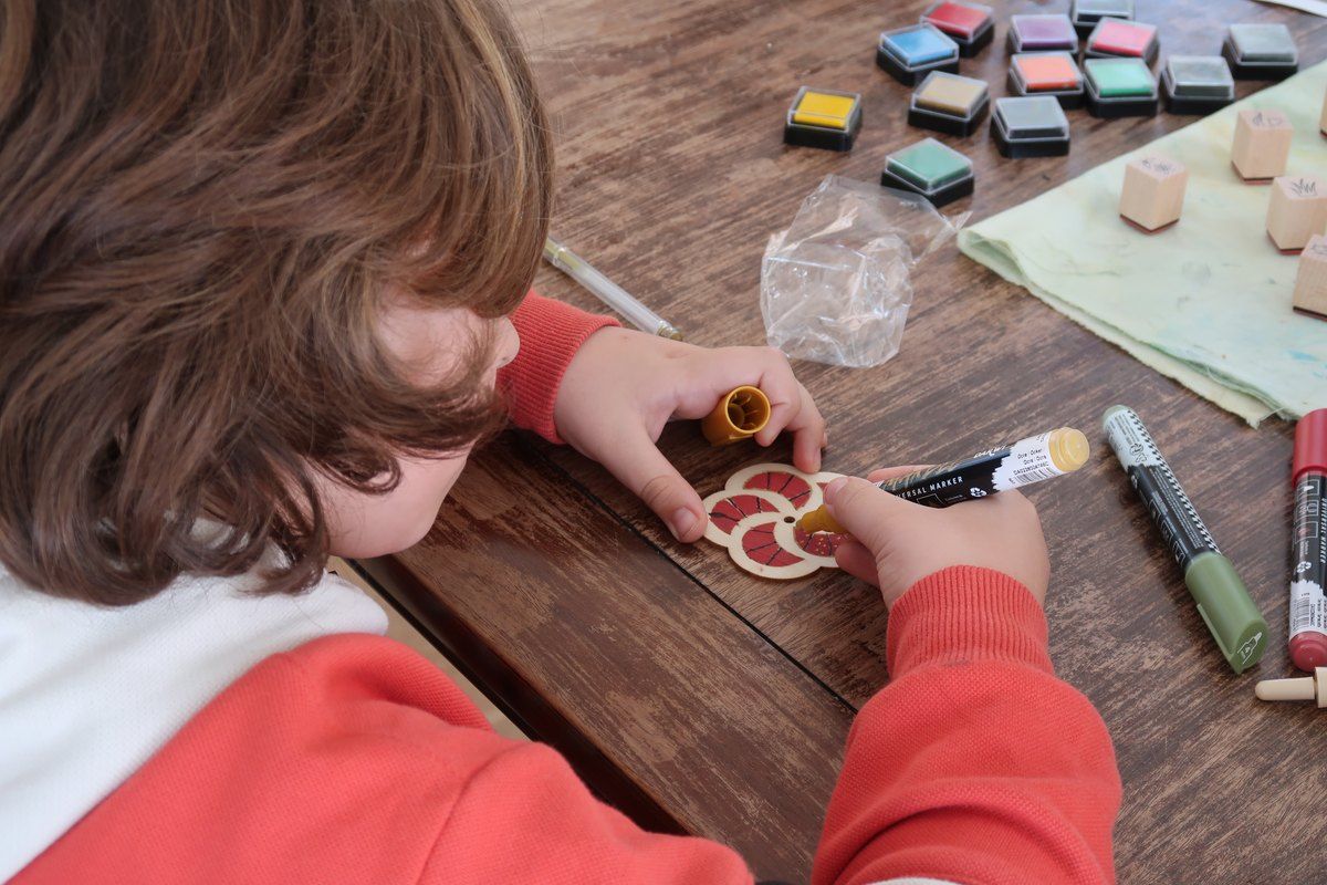 A child stamping patterns at a family workshop in the Musée départemental des Arts Asiatiques, Nice