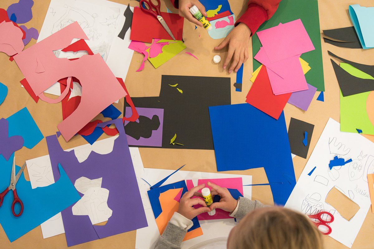 Children cutting coloured paper shapes at a family workshop in the Musée Matisse, Nice