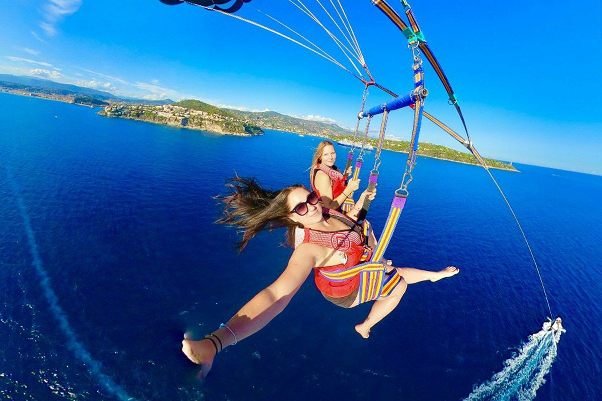 Two passengers parasailing high above the blue sea off the Cap de Nice with SuperFly Watersports