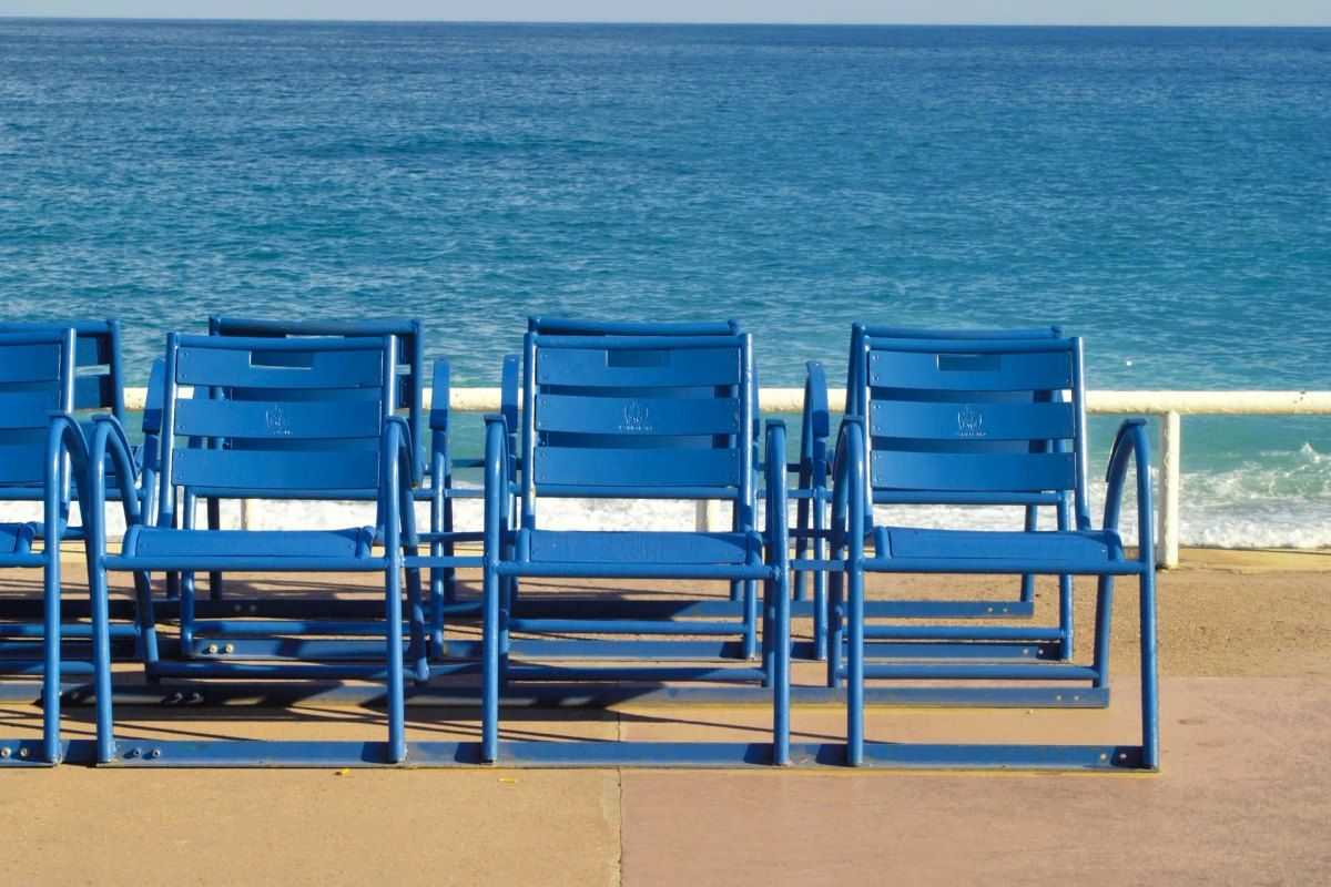 A row of the famous blue chairs facing the sea on the Promenade des Anglais, Nice