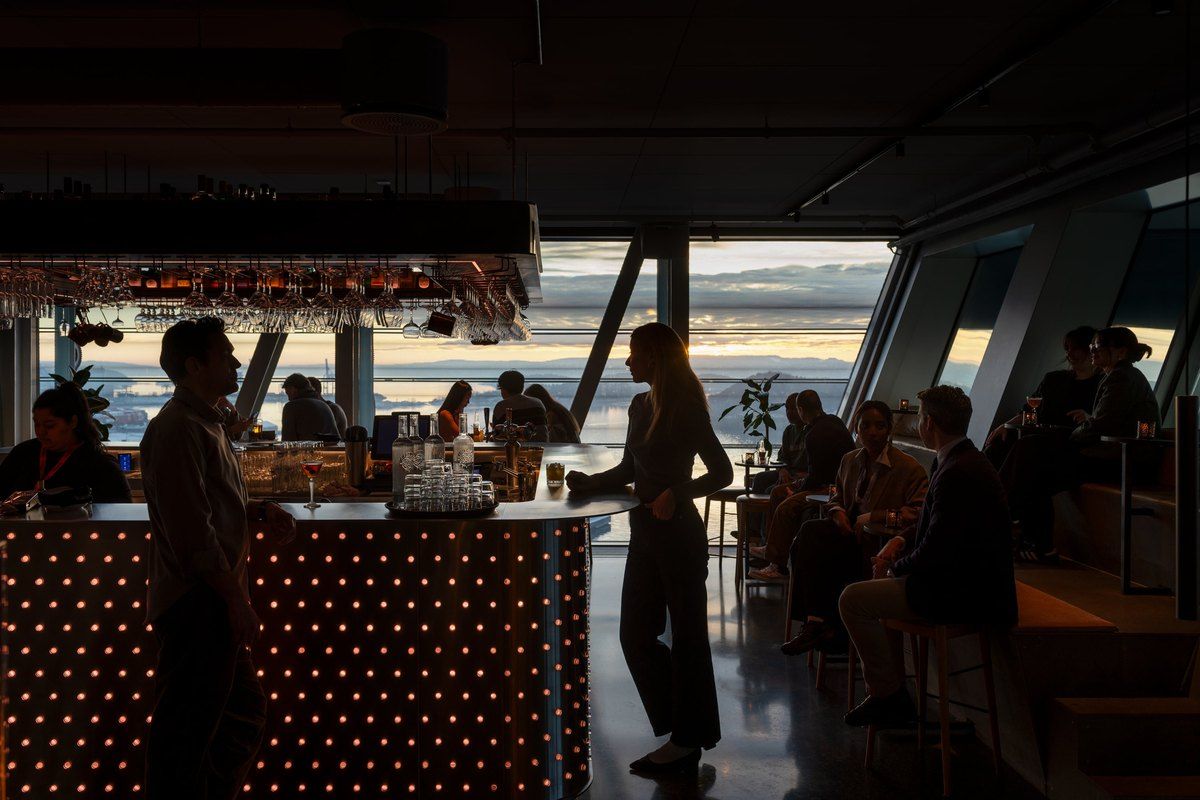 The bar counter on the top floor of MUNCH, with the fjord and evening light through the glass walls