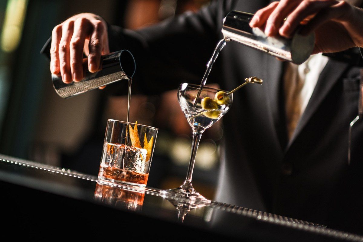 A bartender pouring a martini and an old fashioned on the bar at THIEF Bar, Tjuvholmen