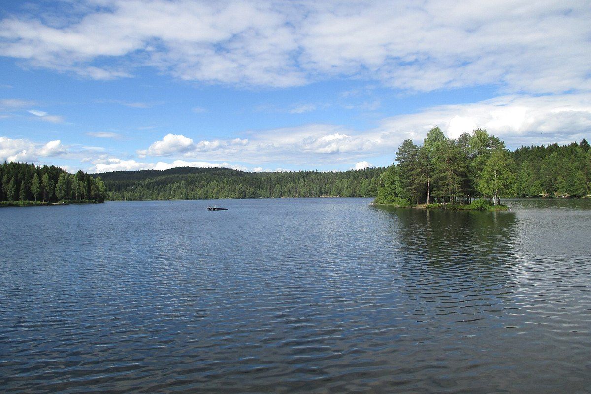 Calm water and a small wooded island on Sognsvann lake at the edge of the Nordmarka forest, Oslo