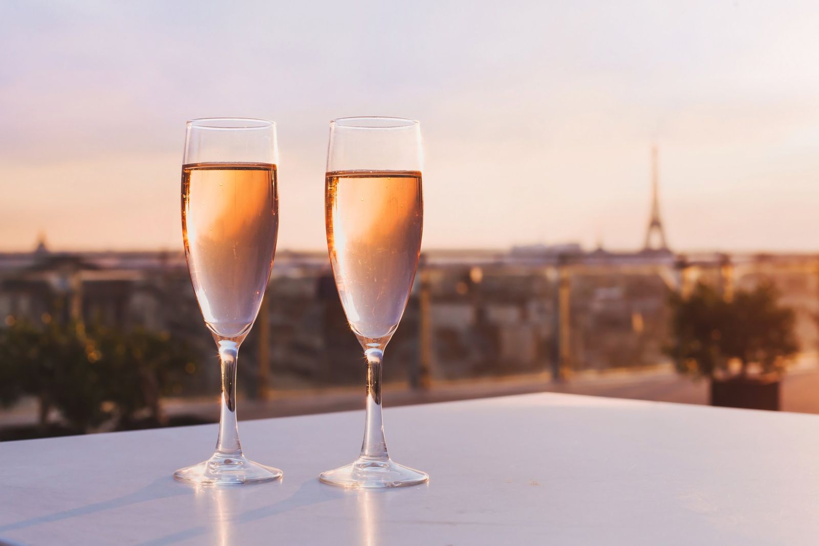 Two glasses of champagne on a rooftop, with the Eiffel Tower beyond