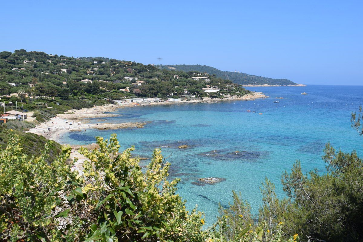 Turquoise water and a small sandy bay below the wooded hills at L'Escalet, Ramatuelle