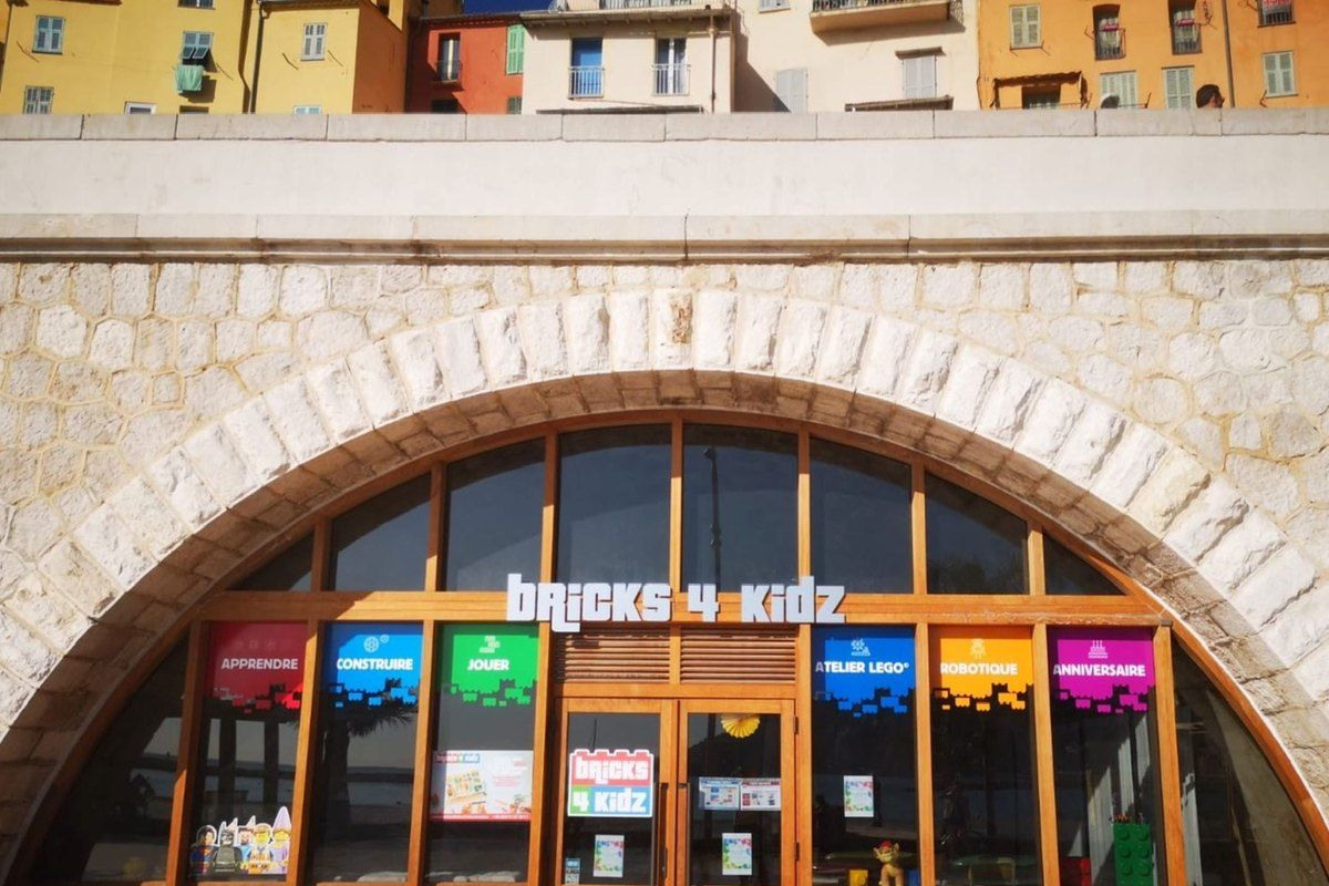 The arched shopfront of Bricks 4 Kidz under the Sablettes esplanade in Menton
