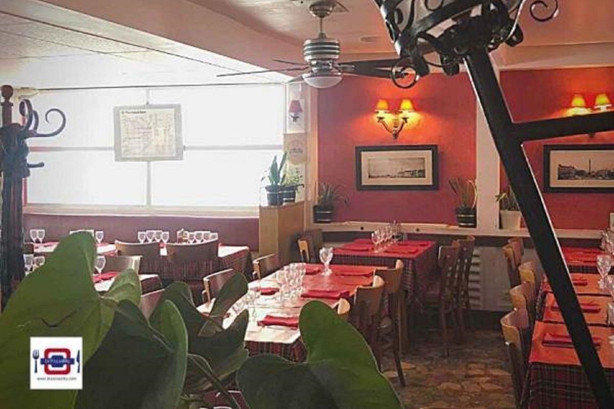 The red-walled dining room of Le Picadilly bar-restaurant in Roquebrune-Cap-Martin, tables laid with red cloths