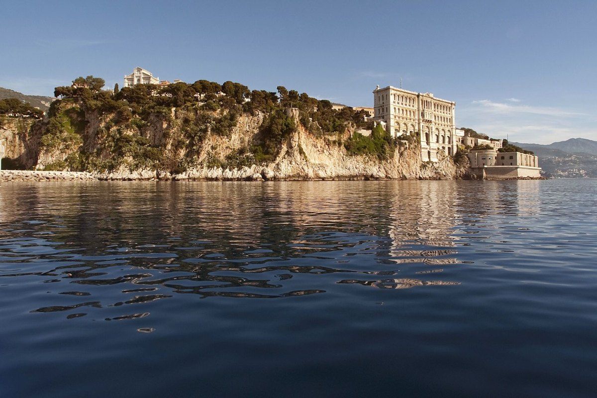 The Musée océanographique on the cliff of the Rock of Monaco, reflected in a calm sea