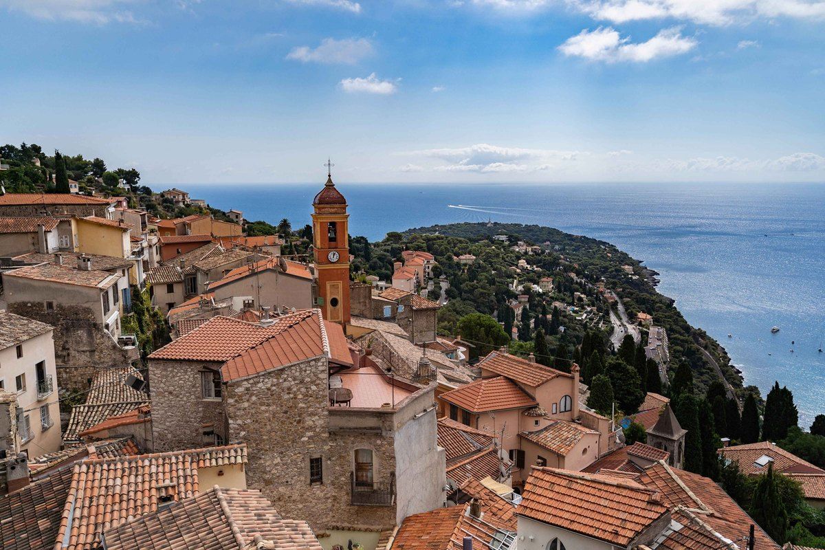 Terracotta rooftops and the church bell tower of Roquebrune village above the sea and Cap Martin