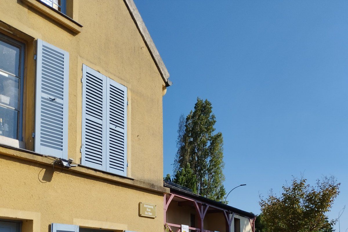 The ochre façade and blue-grey shutters of the Musée Fournaise on the Île des Impressionnistes in Chatou
