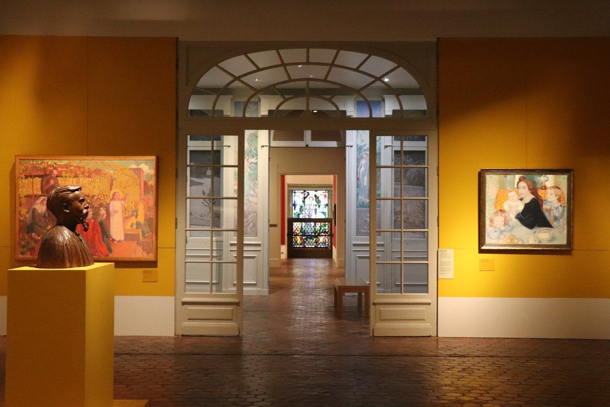 Ochre-walled galleries with paintings and a bust at the Musée Maurice Denis in Saint-Germain-en-Laye
