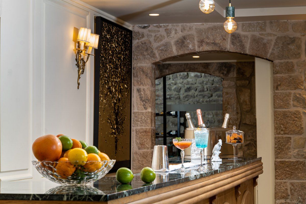 Cocktails and a bowl of citrus on the stone-framed bar of the Hôtel Le Saint-Paul