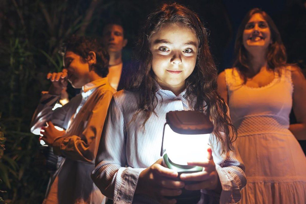 A girl holds a glowing lantern during the evening lantern tour of Saint-Paul de Vence