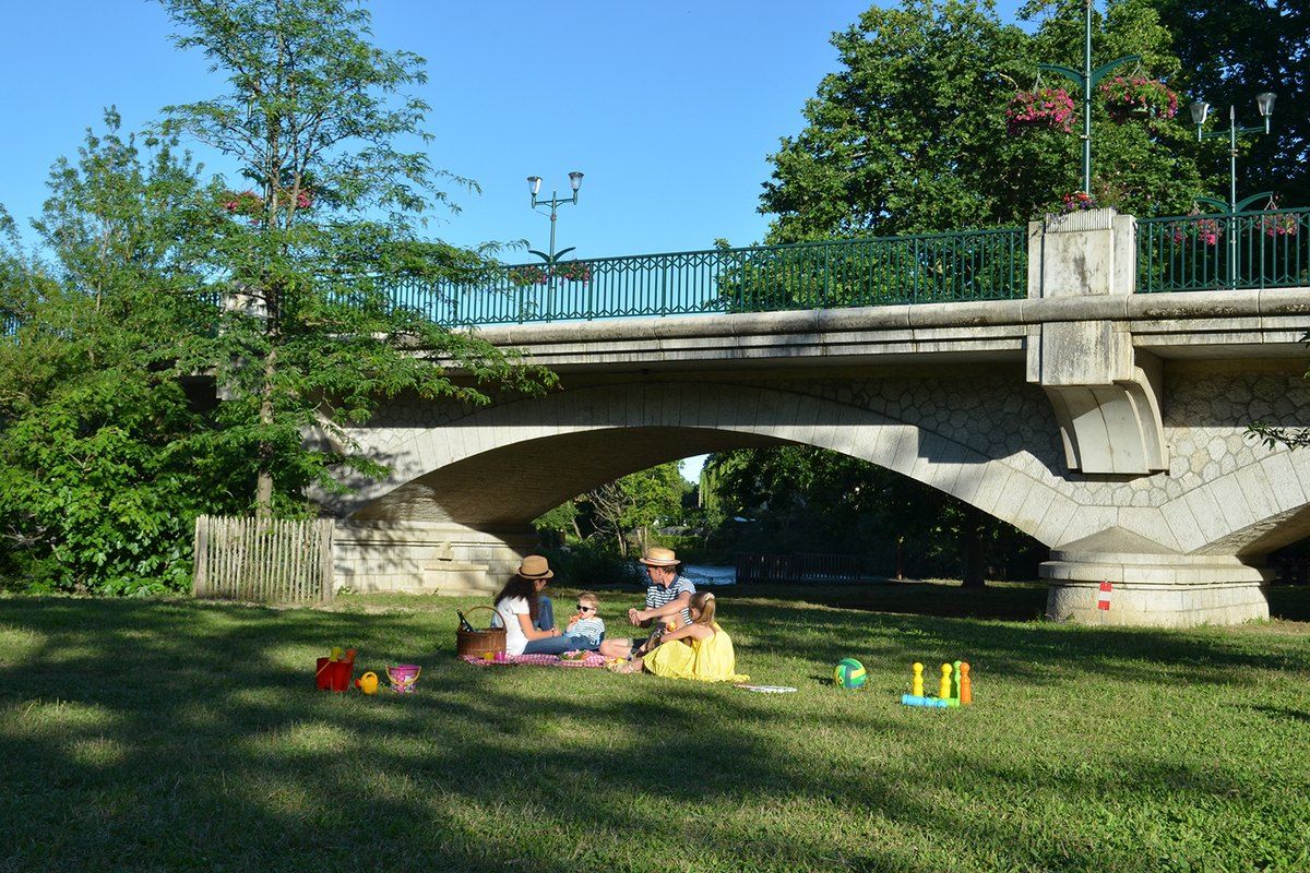 Lawns and a stone bridge over the Loup river in the Parc départemental des Rives du Loup