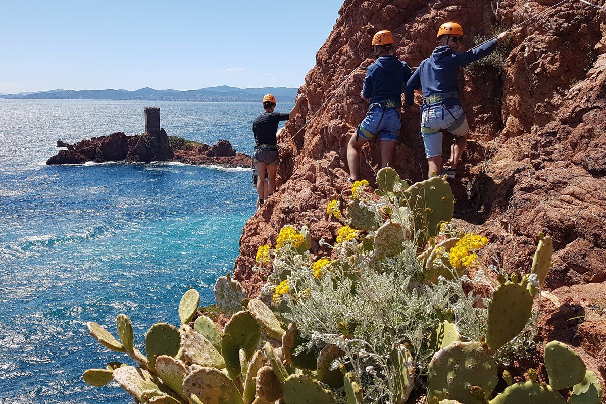 Climbers with Camp 4 on the red rock of Cap Dramont above the sea, the Île d'Or tower beyond