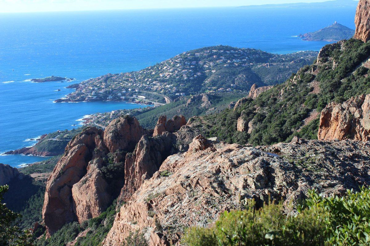 Red rock ridges of Cap Roux dropping to the sea, with Agay bay and the coast beyond