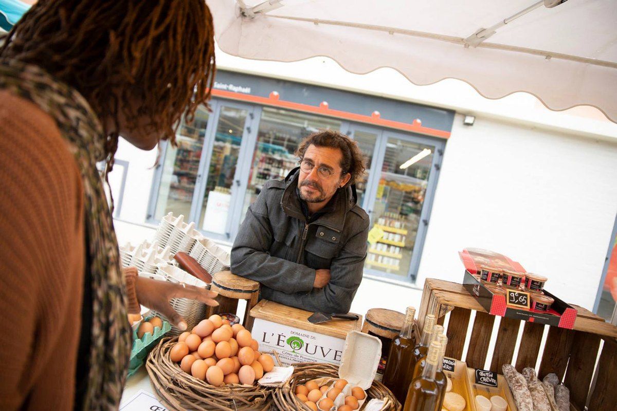 A producer selling eggs from wicker baskets at the Victor Hugo market in central Saint-Raphaël