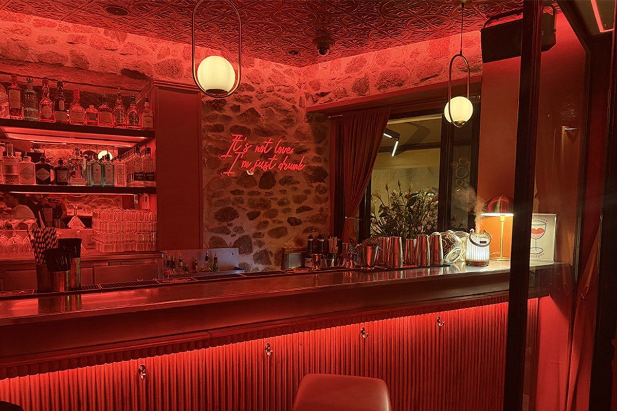 The red-lit bar and stone wall inside Cohibar, Saint-Tropez