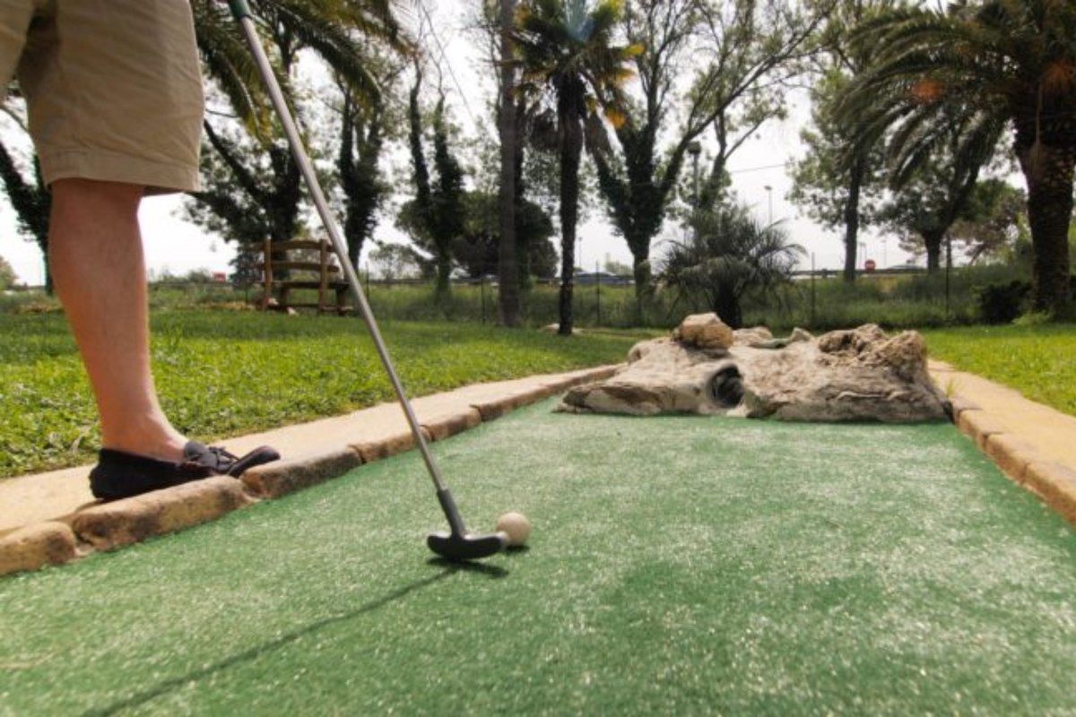 A player putting on the carpeted mini-golf course among the palms at La Palmeraie, Cogolin