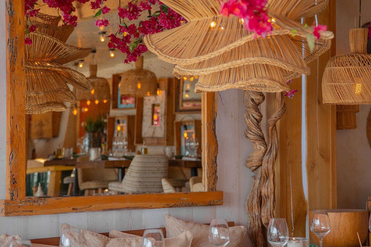 Banquettes, rattan lamps and bougainvillea inside Le Café on the Place des Lices
