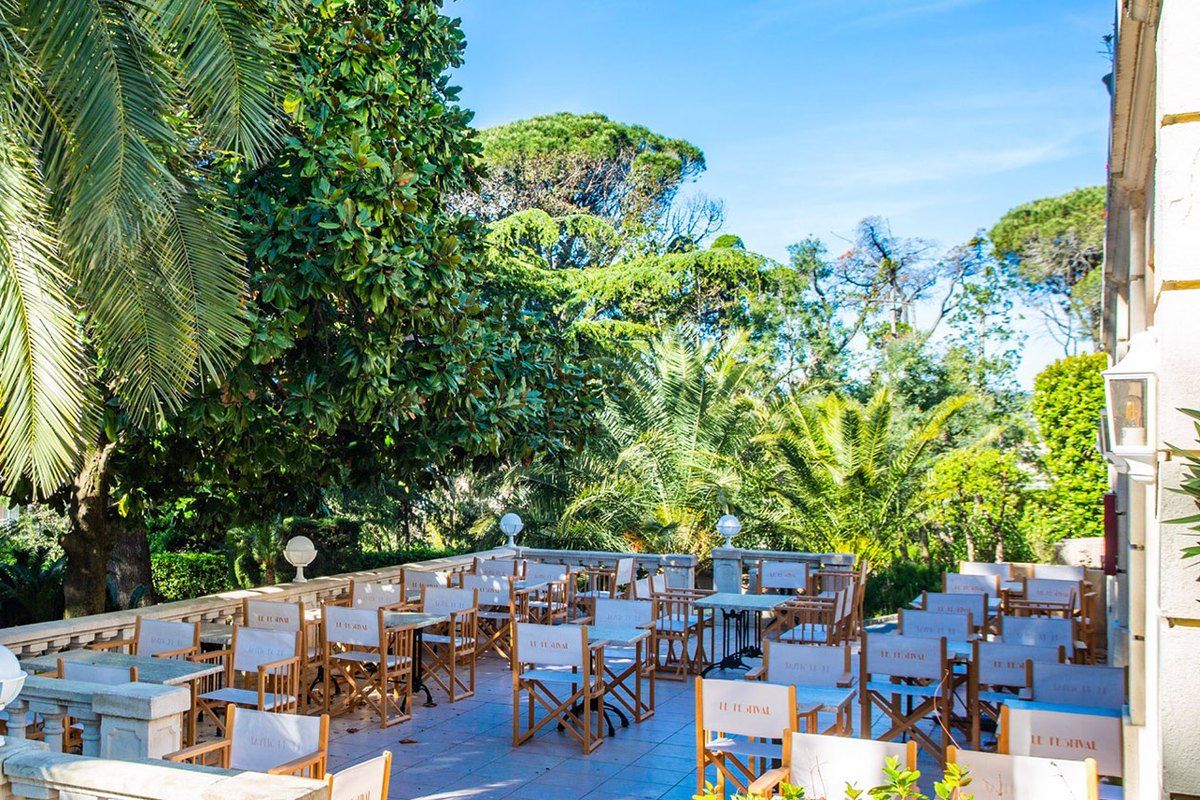 The balustraded terrace of Le Festival in the park of the Château Gaumont, among palms and old trees
