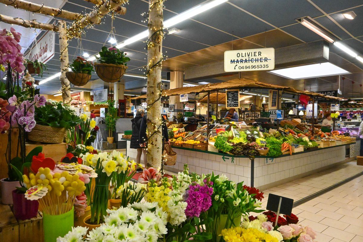 Flowers and a greengrocer's stall inside the Marché couvert of Sainte-Maxime