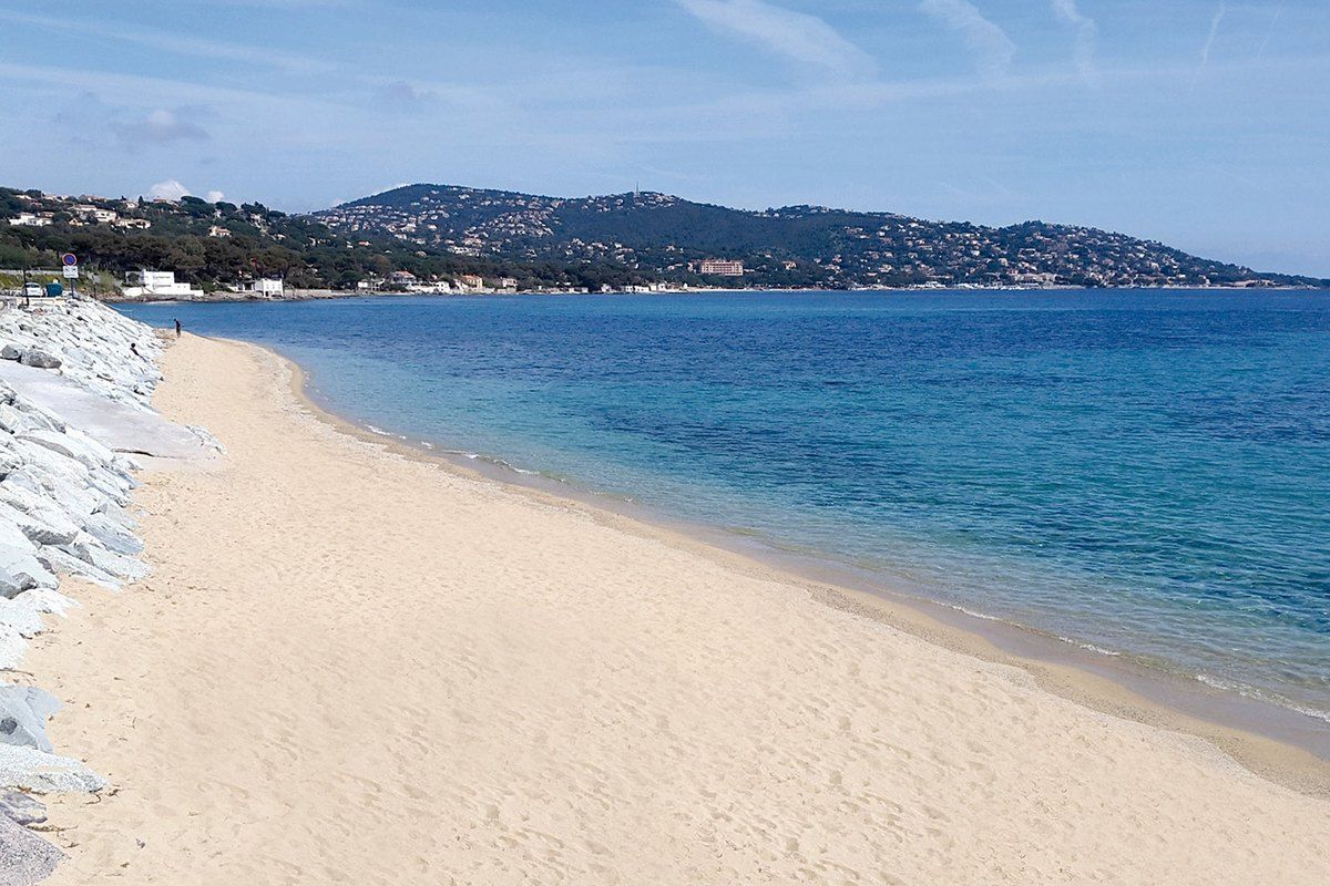Pale sand and clear water at the Plage des Éléphants in Sainte-Maxime, looking across the gulf